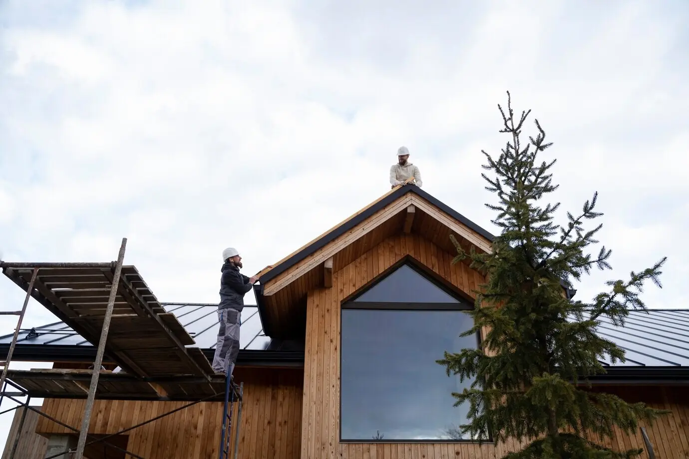 Long shot of men working together on a roof.